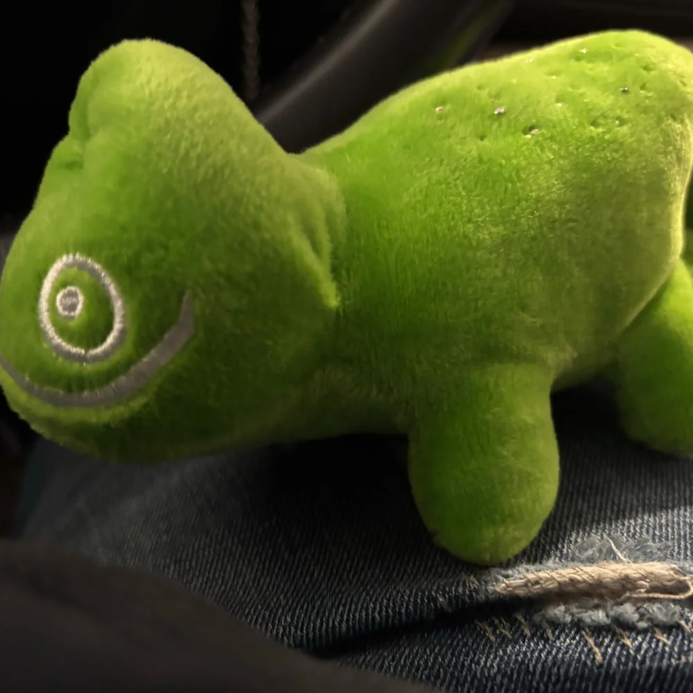 green Geeko chameleon plush toy featuring the SUSE logo